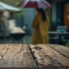 Wooden garden table with people at barbecue grill and garden in background – outdoor cooking...