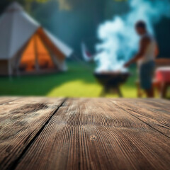 Wooden garden table with people at barbecue grill and garden in background – outdoor cooking...