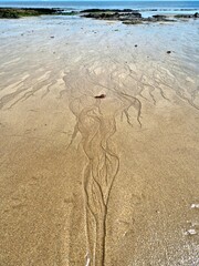 Dramatic pattern in sand at low tide on sandy beach in Ireland