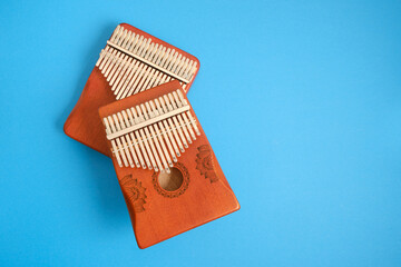 wooden kalimba on blue background, traditional african musical instrument, meditation instrument top view copy space