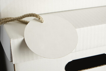 tag and pile of white cardboard boxes with slots for holding, storage boxes