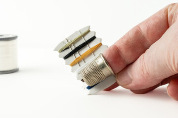 woman holding sewing repair kit with thimble carded cotton threads and stainless steel needles