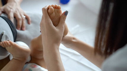 Leg of a newborn in the hands of parents. Newborn baby feet. Little leg of a newborn baby in a big hand of an adult. Baby foot massage.