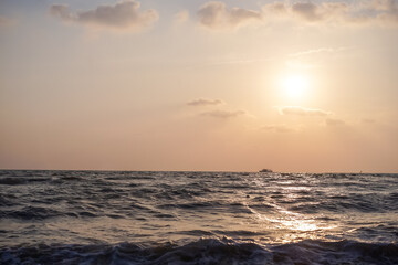 The beautiful scene of Pattaya beach and sea waves with the golden sun and white clouds on the clear sky in the daytime, Thailand.