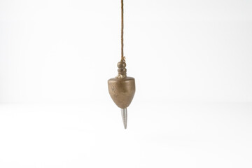 bricklayers antique brass and steel perpendicular guide plumb bob for site work isolated on a white...