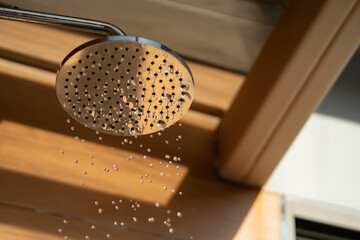 Close up to Outdoor shower head for the bath and showering cold water to body before jumping in the...