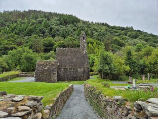 Glendalough, Ireland, in summer. Lush green foliage and ancient monastic remains in the wilderness