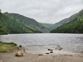 Glendalough, Ireland, in summer. Lush green foliage and ancient monastic remains in the wilderness