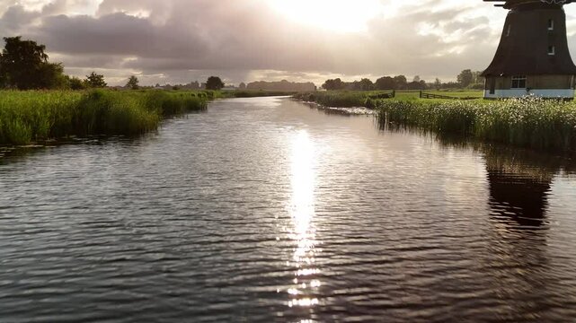 Low and fast drone flyover across sparkling water under strong sunlight in the Netherlands. Shot in 4K on July 2, 2025, showing vivid light, shimmering surface, and intense summer brightness.