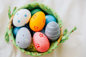 Colorful decorated eggs in a green basket for spring festivities