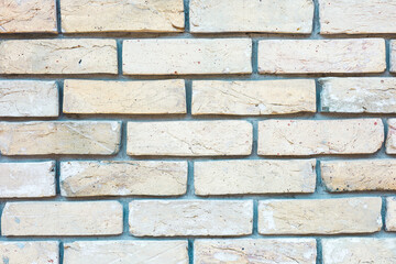 Detailed view of a textured light yellow brick wall showing craftsmanship and design features