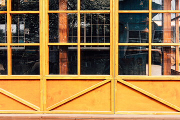 Bright yellow wooden window frames showcase the exterior of a rustic building in daylight