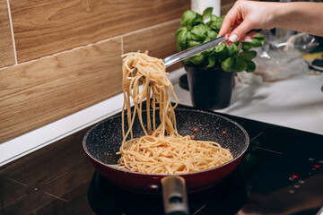 Step by step the process of cooking Italian pasta carbonara in spaghetti, add sauce with fried...