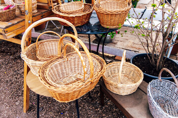 Woven baskets displayed on rustic wooden shelves at an outdoor market in spring