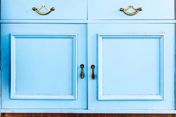 Classic blue cabinet with elegant golden handles in modern interior setup