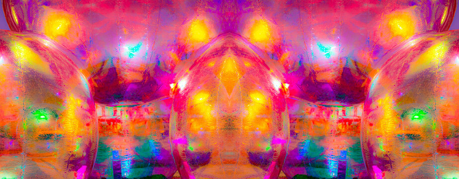 A vibrant, abstract artwork featuring a close-up of a shiny, surface reflecting multicolored light. The dominant hues are red, orange, yellow, and pink, with hints of blue and green.