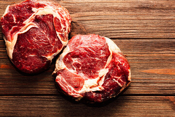Fresh cuts of beef displayed on a rustic wooden table ready for cooking