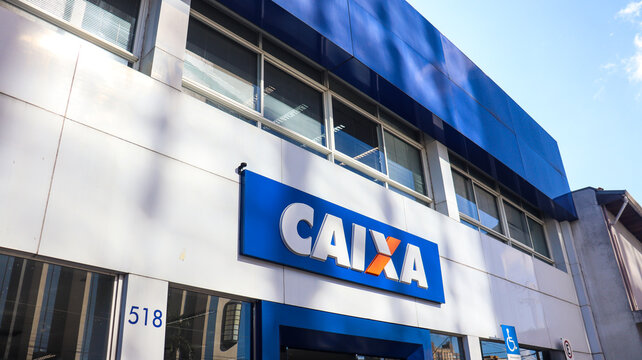 Fachada de uma ag&ecirc;ncia da Caixa Econ&ocirc;mica Federal com totem vis&iacute;vel e sinaliza&ccedil;&atilde;o clara, representando os servi&ccedil;os financeiros p&uacute;blicos no Brasil. Mogi das Cruzes SP em 10 julho 25