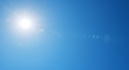 Bright sun radiating light against a clear, vibrant, and cloudless blue sky.