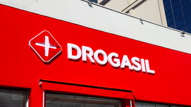 Fachada da farm&aacute;cia Drogasil no Brasil. Logotipo vermelho em destaque, ambiente urbano e &aacute;rea de entrada vis&iacute;veis. S&atilde;o Paulo SP em 06 julho 25