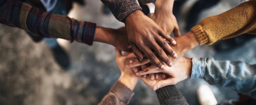 The united hands of diverse individuals coming together in solidarity and support.