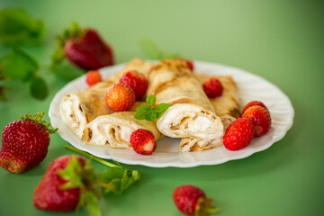 Sweet pancakes with cottage cheese and strawberries on top
