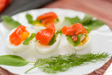 Decorated eggs with red fish and herbs on the table