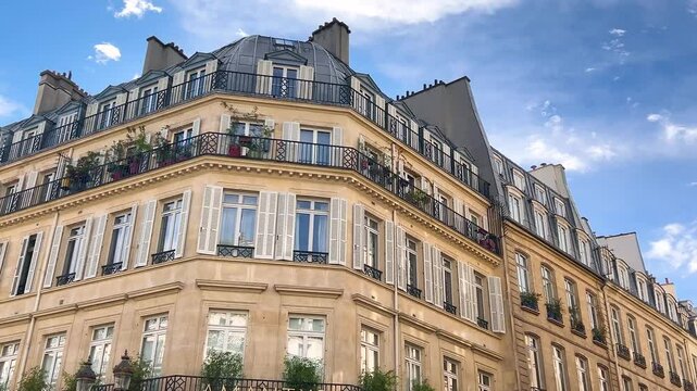 Facade of beautiful historic buildings and blue sky with clouds on a sunny day in Paris, France.