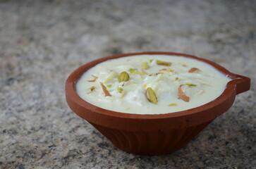 Traditional Indian dessert rabdi – thick, creamy milk-based sweet slow-cooked with sugar, cardamom, and saffron, garnished with dry fruits – served chilled in bowl, festive sweet