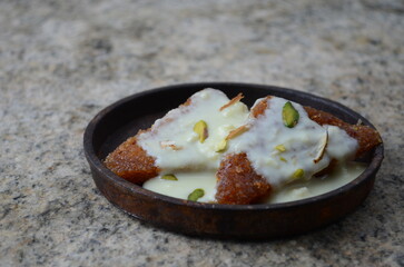 Royal Indian dessert shahi tukda with rabdi – deep-fried bread slices soaked in sugar syrup, topped with thick saffron-infused rabdi and dry fruits – rich festive sweet