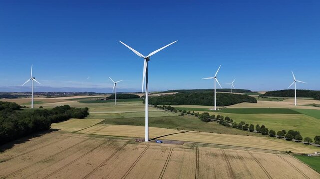 &eacute;oliennes en fonction au milieu des cultures en Lorraine avec un ciel bleu sans nuages