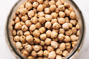 Chickpeas in glass jar. Dried legumes in top-down view. Healthy plant-based protein source. Natural...