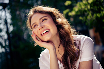 Charming woman enjoying a sunny day outdoors with a cheerful smile showcasing happiness and leisure...