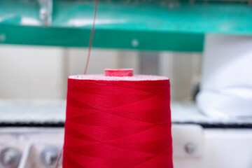 Zoom sur une bobine de fils rouges dans une usine, utilisée pour fermer et sceller les sacs de...