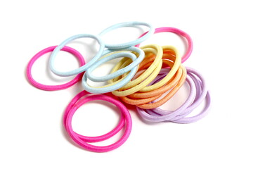 There are many hair ties lying on a white background.