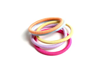 There are many hair ties lying on a white background.