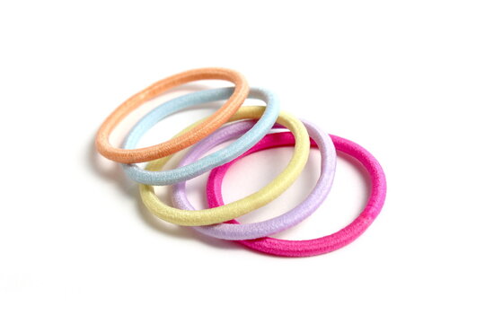 There are many hair ties lying on a white background.