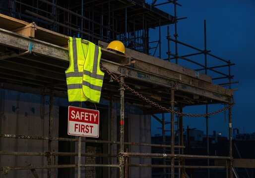 Construction Site at Dusk with "Safety First" Sign - Evocative scene depicting ongoing building projects, workplace safety, and the construction industry during twilight hours.