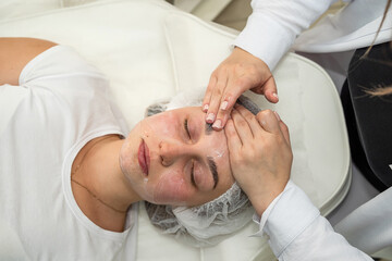 Beautiful young girl receive nourishing cream on here face, spa procedures