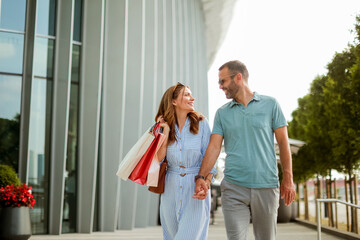 Enjoying a vibrant day of shopping and laughter in a modern urban setting under a bright blue sky