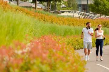 Couple enjoying a morning jog through a vibrant park trail