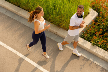 Joyful morning joggers enjoying the sunshine along a scenic pathway surrounded by green grass and vibrant nature