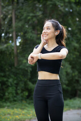 Fototapeta premium Portrait of runner looking at smart watch on her wrist check her heart rate and jogging distance. runner is paying attention her smart watch on wrist check her heart rate and jogging distance.