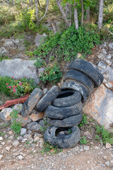 Old car tires lie on the side of the road