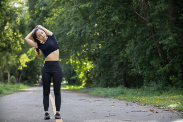 Portrait of beautiful female runner wearing workout clothes and warm up her body get ready for...