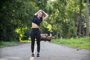 Portrait of beautiful female runner wearing workout clothes and warm up her body get ready for...