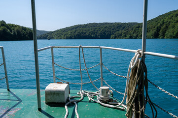 Railing of a boat on a lake with forest