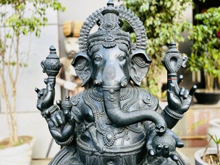 Stone statue of Lord Ganesha with intricate craftsmanship placed outdoors