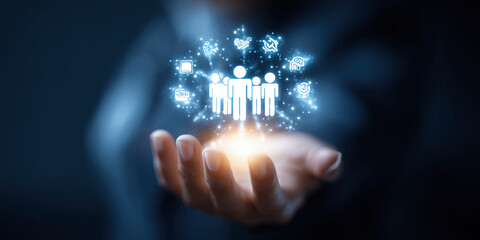 Businessman holding digital icons of people and team management, representing human resources, recruitment, employee data, business leadership, and digital HR solutions.