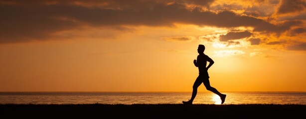 The runner silhouette against a beautiful sunset by the ocean shoreline.